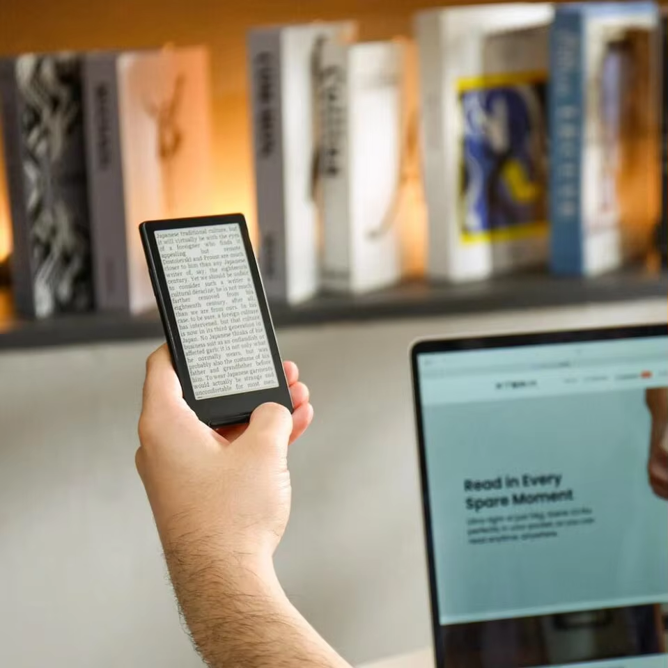 XTEINK X4 Classic held in one hand near a bookshelf